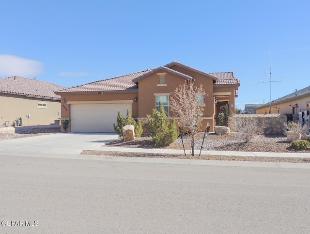 view of front of house with concrete driveway, a tile roof, an attached garage, and stucco siding