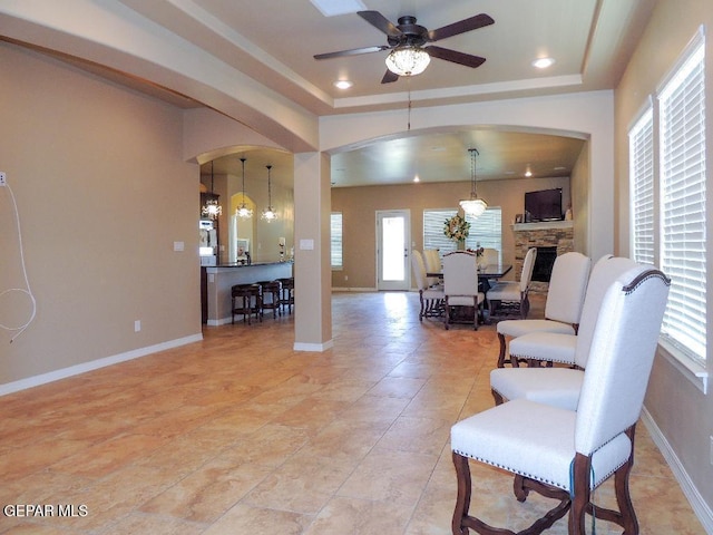 7876 Enchanted Path Dr, El Paso, TX 79911 - living room with arched walkways, ceiling fan, a raised ceiling, healthy amount of natural light, and recessed lighting
