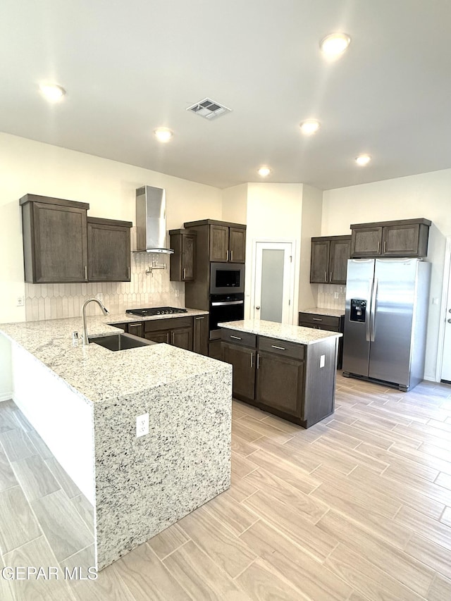 3872 Surmise St, El Paso, TX 79938 - kitchen with wall chimney range hood, dark brown cabinets, visible vents, stainless steel appliances, and a sink