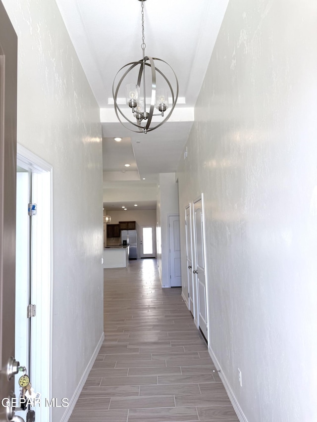 3872 Surmise St, El Paso, TX 79938 - corridor featuring light wood-type flooring, a notable chandelier, and baseboards