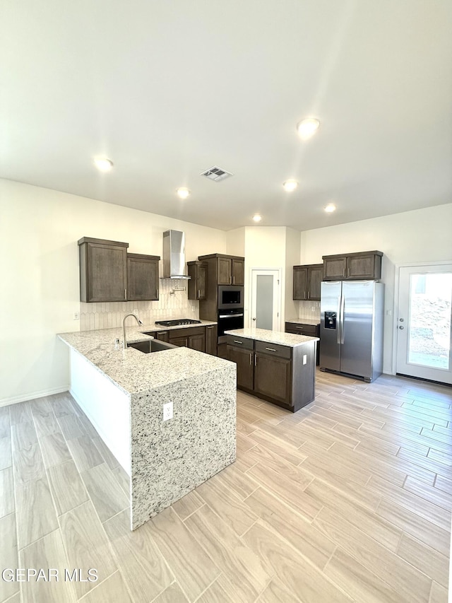 3872 Surmise St, El Paso, TX 79938 - kitchen with wall chimney range hood, dark brown cabinets, visible vents, appliances with stainless steel finishes, and a sink