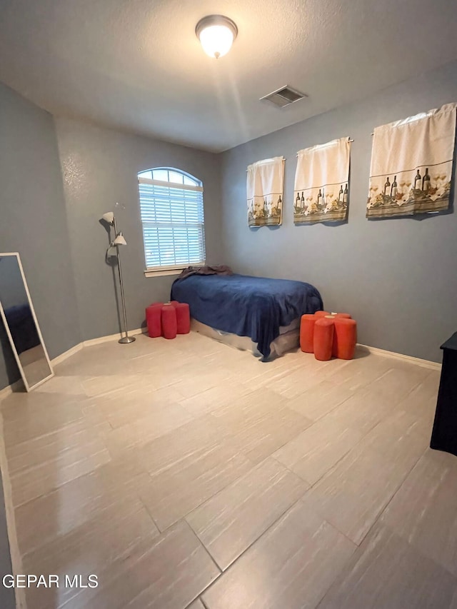 bedroom featuring wood-type flooring and a textured ceiling