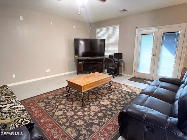 tiled living room with french doors and a healthy amount of sunlight