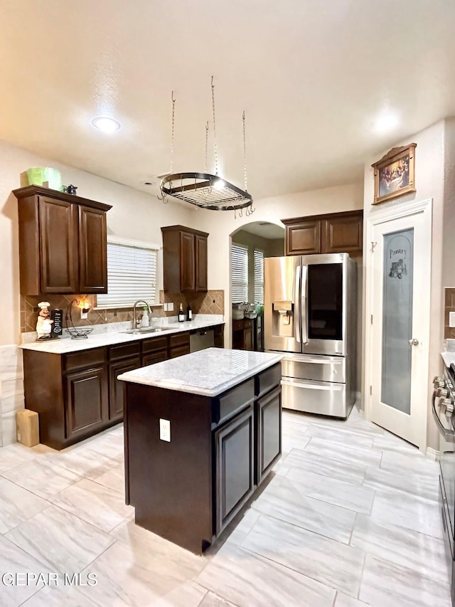 3165 Destiny Point Dr, El Paso, TX 79938 - kitchen featuring dark brown cabinetry, a kitchen island, appliances with stainless steel finishes, arched walkways, and a sink