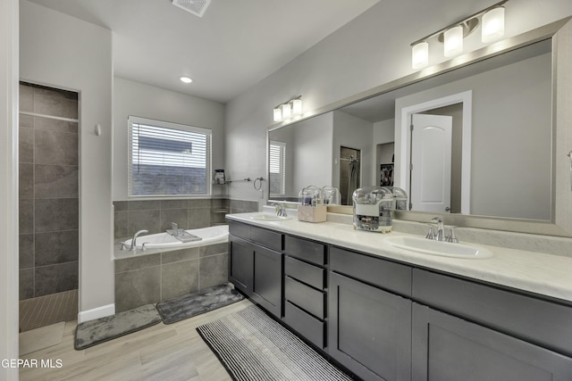 bathroom featuring plus walk in shower and vanity