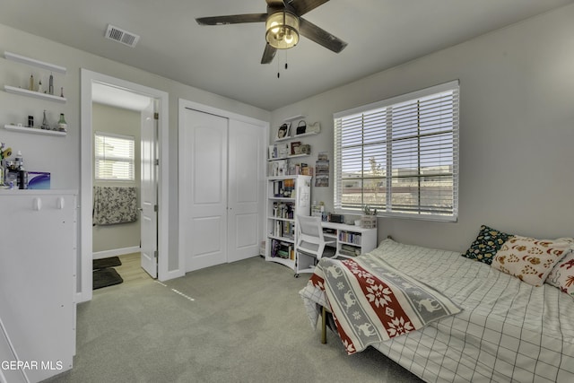 bedroom featuring a closet, light colored carpet, and ceiling fan