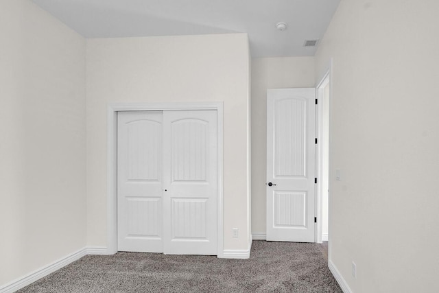 unfurnished bedroom featuring carpet and a closet