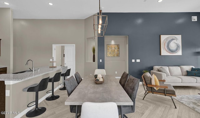 dining room featuring sink and light parquet flooring