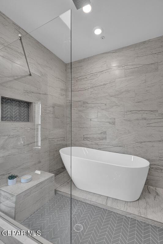 bathroom featuring independent shower and bath and tile walls