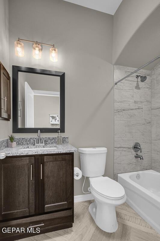 full bathroom with toilet, vanity, and tiled shower / bath combo