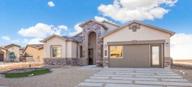 mediterranean / spanish-style home with stone siding and stucco siding