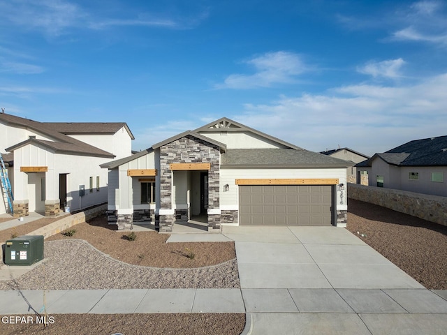 view of front of house with an attached garage, stone siding, and concrete driveway