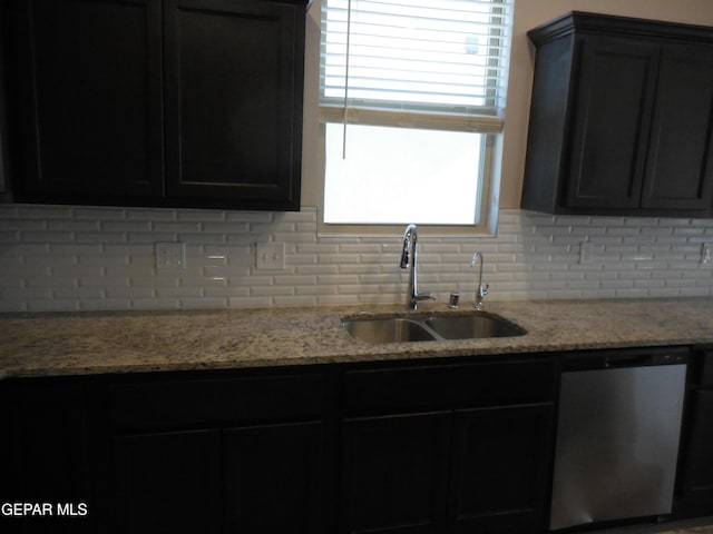 kitchen with sink, tasteful backsplash, light stone countertops, and dishwasher