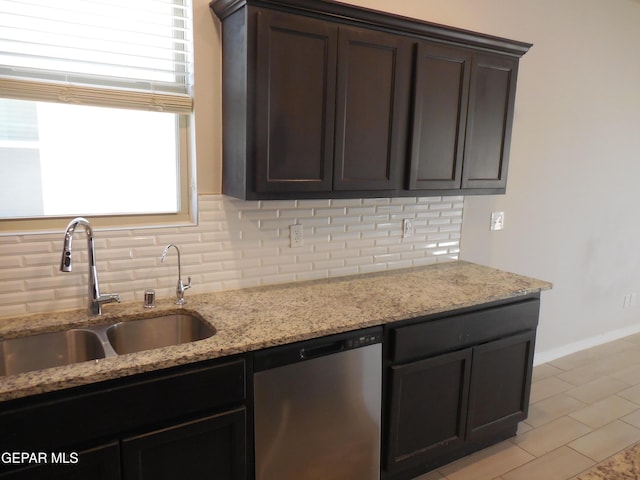 kitchen with dark brown cabinets, dishwasher, light stone counters, backsplash, and sink