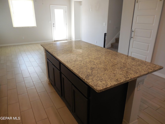 kitchen with a center island and light stone counters