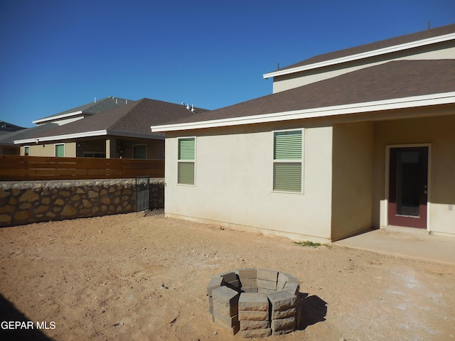 rear view of property featuring a fire pit