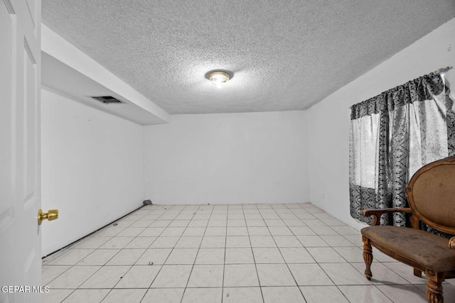 interior space featuring light tile patterned flooring and a textured ceiling