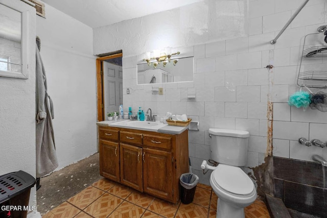 bathroom with toilet, tile walls, and vanity