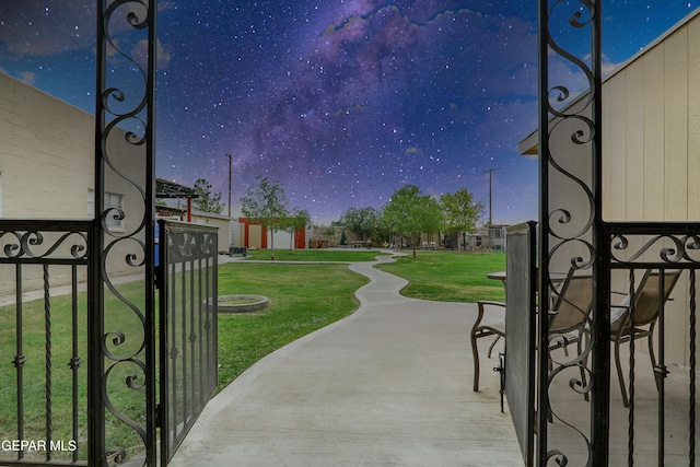 view of gate with a lawn