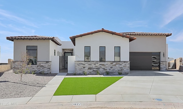 mediterranean / spanish home with driveway, stone siding, a tile roof, an attached garage, and stucco siding