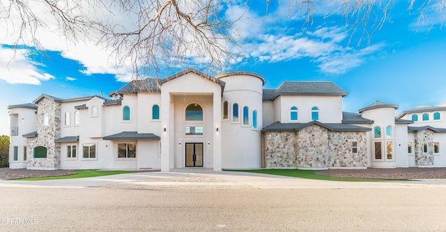 mediterranean / spanish home featuring stone siding and stucco siding