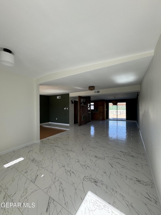 empty room featuring marble finish floor, visible vents, and baseboards