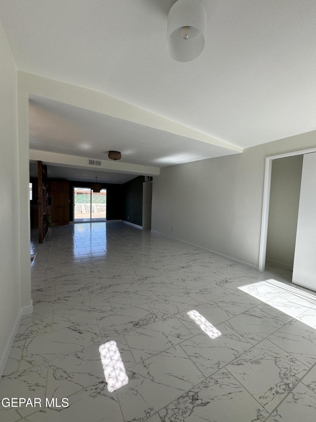 empty room featuring marble finish floor, baseboards, and visible vents