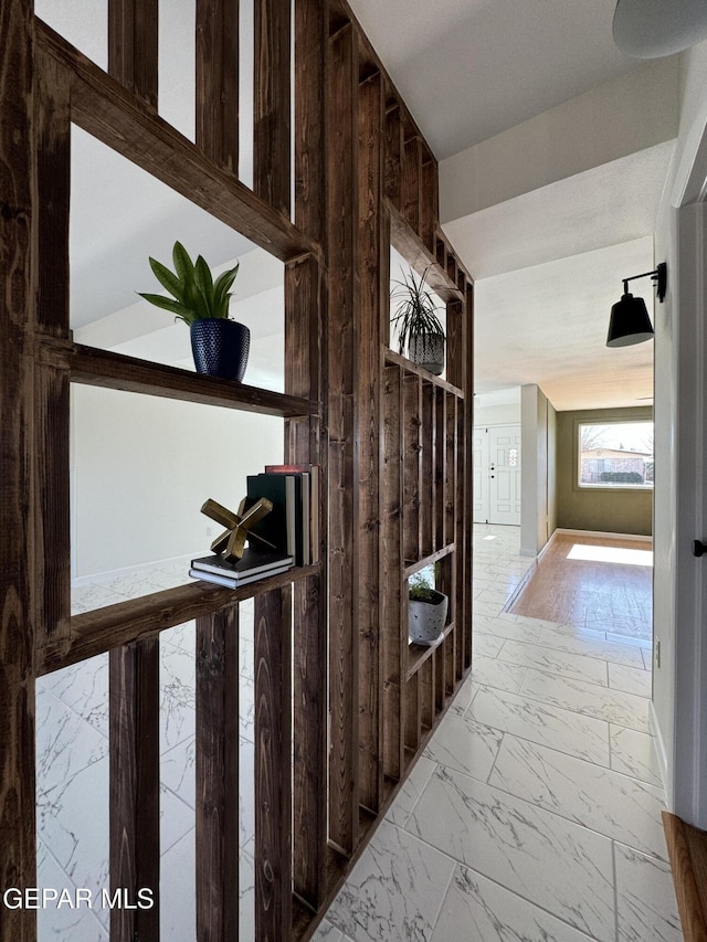 hallway featuring marble finish floor