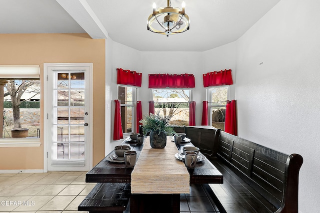 dining room with baseboards, a chandelier, and tile patterned floors