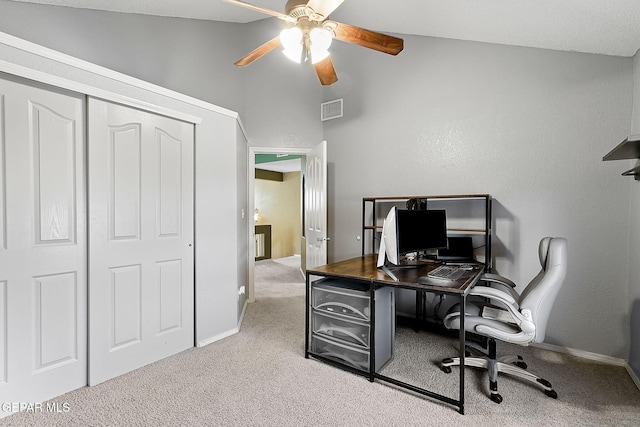 carpeted office space featuring a ceiling fan, visible vents, vaulted ceiling, and baseboards