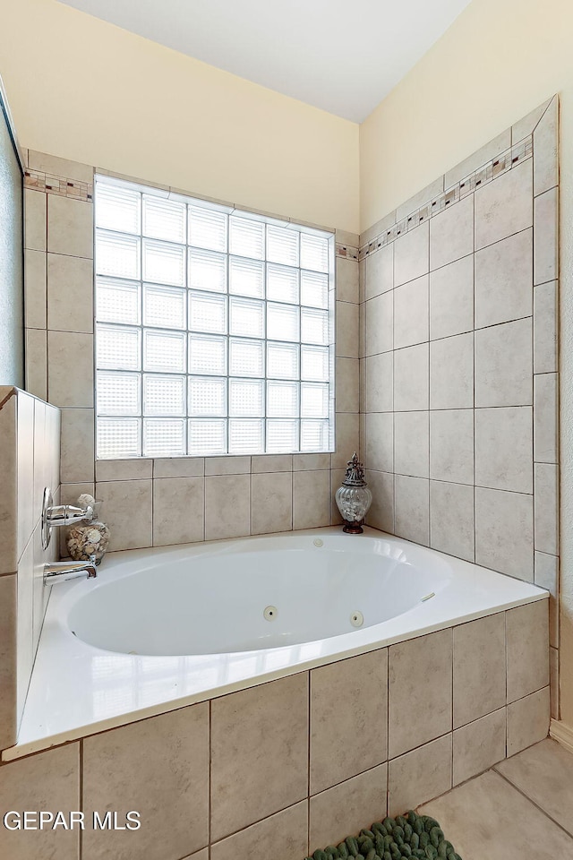 full bathroom with a healthy amount of sunlight, a whirlpool tub, and tile patterned floors