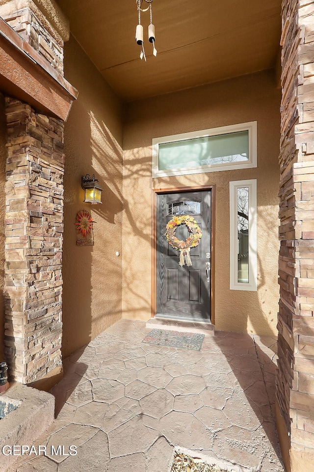 doorway to property featuring stucco siding