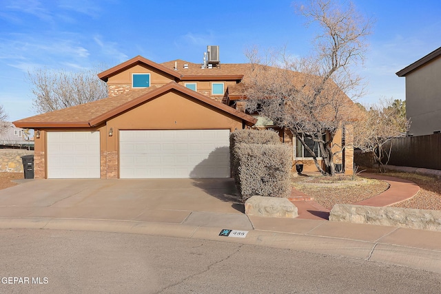 view of front of house featuring a garage, fence, concrete driveway, and stucco siding