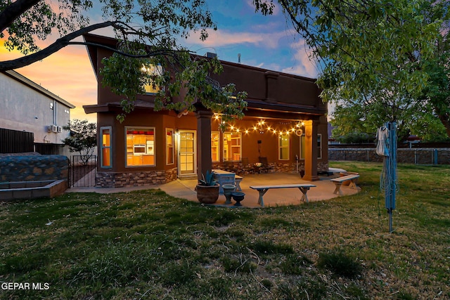 rear view of house featuring a yard, a patio, fence, and a gate