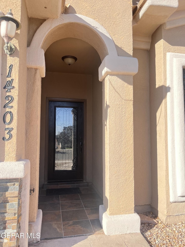 doorway to property featuring stucco siding