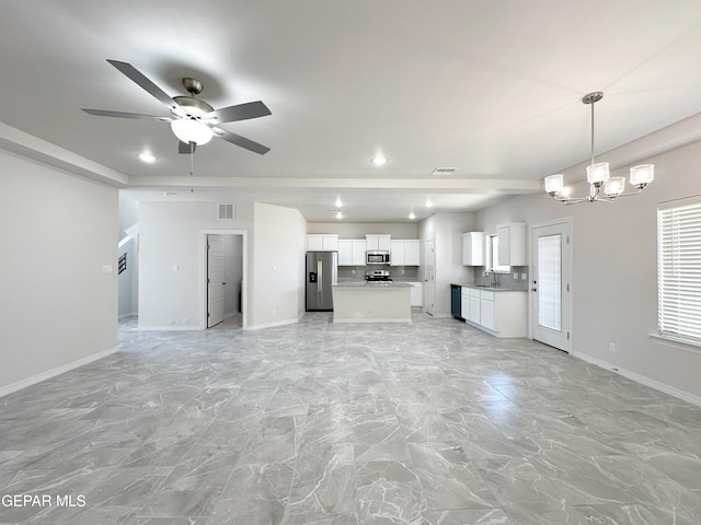 unfurnished living room featuring visible vents, a sink, and baseboards