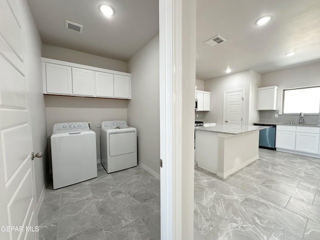 washroom with marble finish floor, washing machine and dryer, visible vents, and a sink