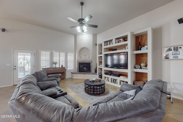 living room with built in shelves, light tile patterned floors, visible vents, a lit fireplace, and baseboards