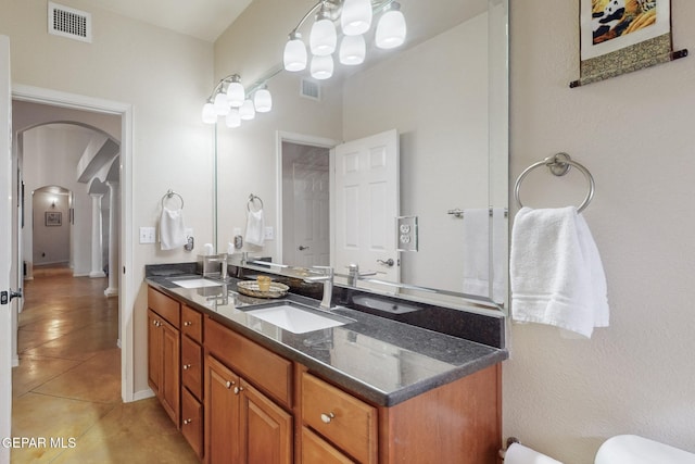 bathroom featuring tile patterned floors, visible vents, a sink, and double vanity