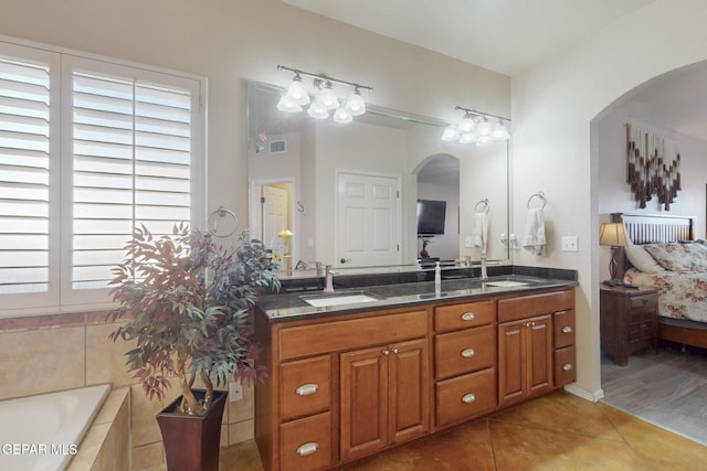 bathroom featuring double vanity, visible vents, ensuite bath, tile patterned floors, and a sink