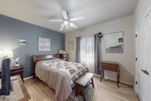 bedroom with a closet, light wood-type flooring, a ceiling fan, and baseboards