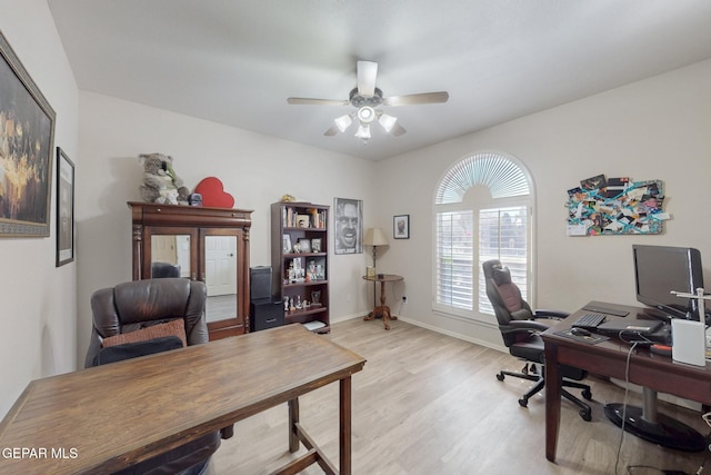 office featuring baseboards, a ceiling fan, and light wood-style floors