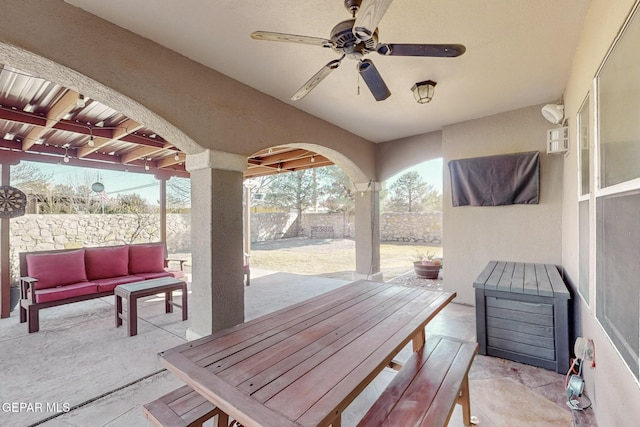 view of patio with outdoor dining area, a fenced backyard, ceiling fan, and an outdoor hangout area