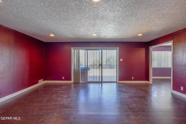 unfurnished room with a textured ceiling and dark hardwood / wood-style flooring