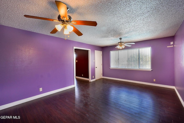 empty room with ceiling fan, dark wood-type flooring, and a textured ceiling