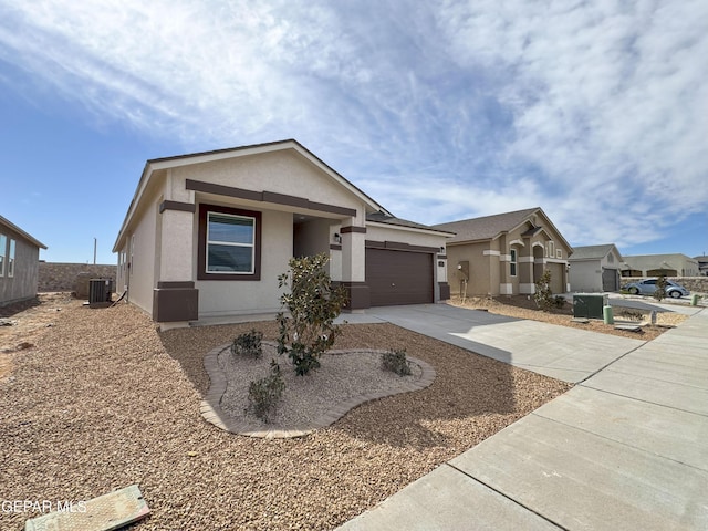 view of front of home featuring a garage, cooling unit, driveway, and stucco siding