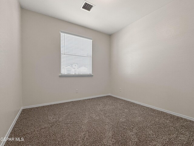 carpeted empty room featuring baseboards and visible vents