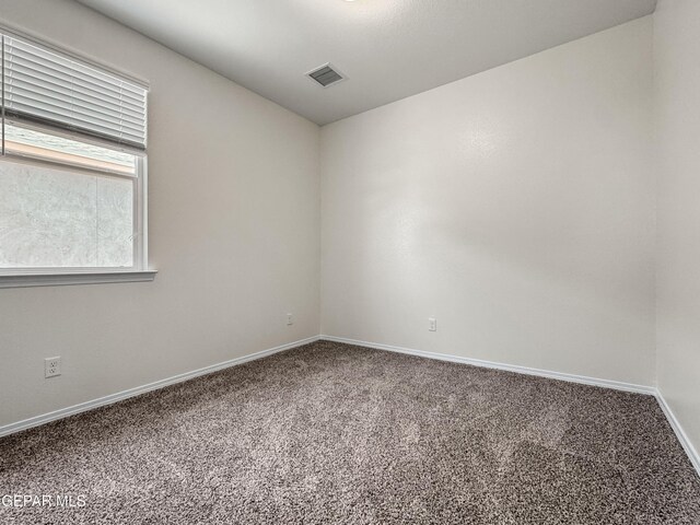 unfurnished room with carpet floors, baseboards, and visible vents