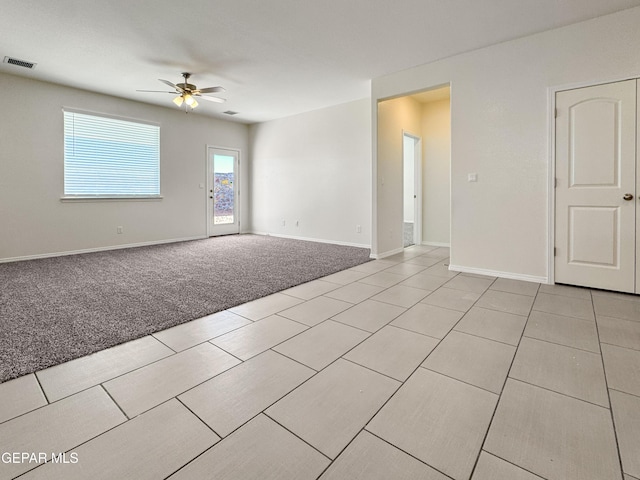 empty room featuring visible vents, ceiling fan, light carpet, and baseboards