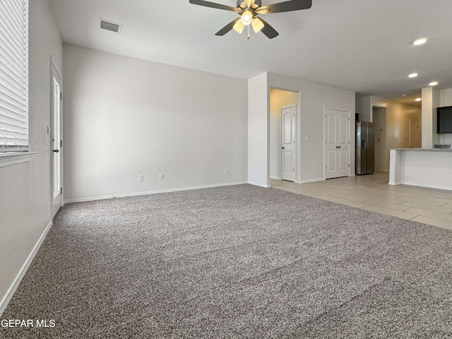 unfurnished living room with ceiling fan, recessed lighting, light carpet, visible vents, and baseboards